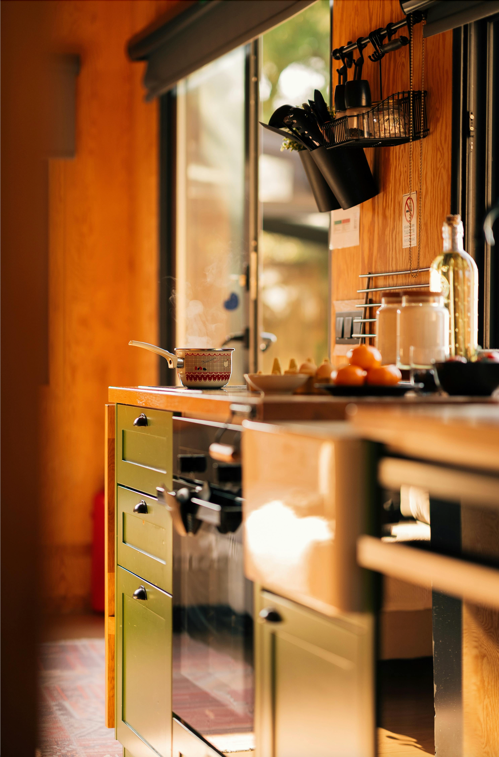 A warm, inviting kitchen space featuring natural light, wooden countertops, and eco-friendly home products arranged neatly.
