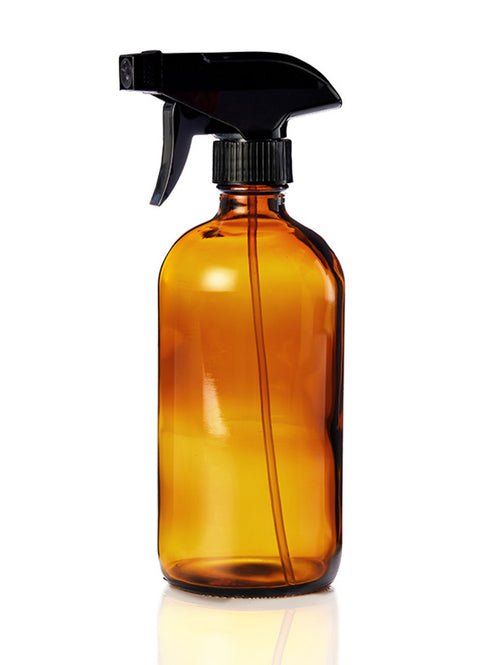 Amber glass spray bottle with black sprayer on a white background